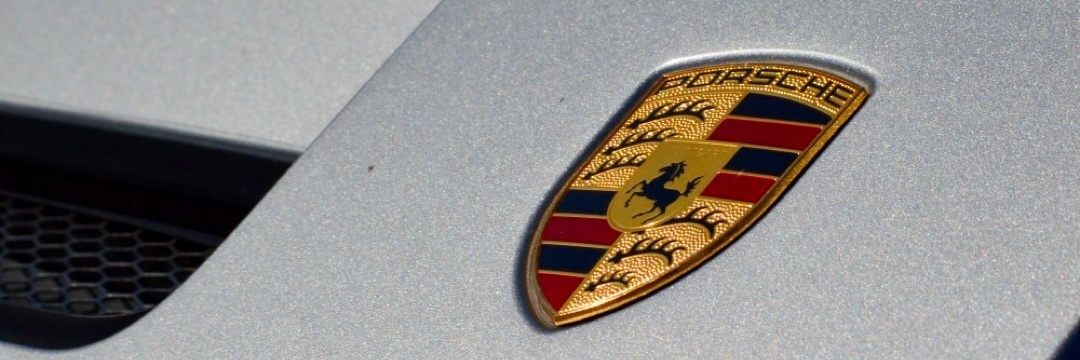 Porsche crest badge on hood, close-up