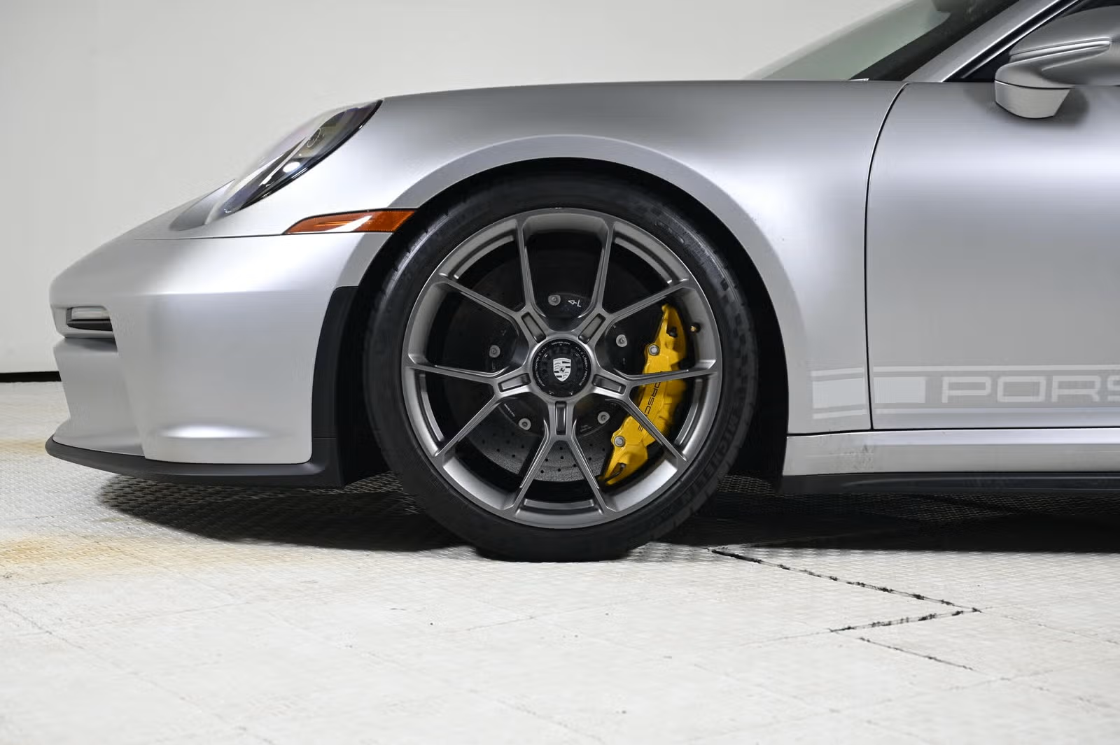 Wheel close-up showing Satin Dark Silver finish and yellow PCCB caliper